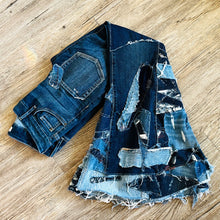 Load image into Gallery viewer, Upcycled from a collection of salvaged denim threads, including denim pants from a professional painter. Base jeans are from GUESS Womens size 27 fit, and in excellent condition! Some give/stretch denim with some intentional distress and random pockets. Added denim bits and pieces to create wide-flared bottoms. 