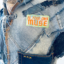 Load image into Gallery viewer, Upcycled from a collection of salvaged denim pants and a hand embroidered patch: BE YOUR OWN MUSE. Pow!! Oversized hoodie, sprinkles of sashiko stitching, random pockets, a lots of intentional distressed pieces, adding character and super urban vibes. Lightweight, with a gathering on the sides to keep a little fitted to your body. This piece is a perfect layer of warmth and FLY. 