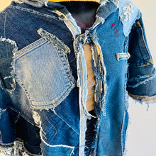 Load image into Gallery viewer, Upcycled from a collection of salvaged denim pants. Oversized hoodie, sprinkles of sashiko stitching, random pockets, a lots of intentional distress. Lightweight, with more denim for ties on the sides to keep a little fitted to your body. A perfect layer of warm and fresh. 
Handcrafted with love and intention.
Upcycled Capelet Jacket
Urban vibes
One-of-a-kind
All size
Handmade in Santa Cruz, CA