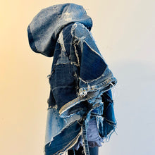 Load image into Gallery viewer, Upcycled from a collection of salvaged denim pants. Oversized hoodie, sprinkles of sashiko stitching, random pockets, a lots of intentional distress. Lightweight, with more denim for ties on the sides to keep a little fitted to your body. A perfect layer of warm and fresh. 
Handcrafted with love and intention.
Upcycled Capelet Jacket
Urban vibes
One-of-a-kind
All size
Handmade in Santa Cruz, CA