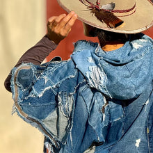 Load image into Gallery viewer, Upcycled from a collection of salvaged denim pants. Oversized hoodie, sprinkles of sashiko stitching, random pockets, a lots of intentional distress. Lightweight, with more denim for ties on the sides to be more fitting, or let loose and be more free flowing. A perfect layer of warm and fresh. 
Handcrafted with love and intention.
Upcycled Capelet Jacket
Urban vibes
One-of-a-kind
All size
Handmade in Santa Cruz, CA