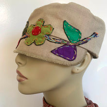 Load image into Gallery viewer, One of a kind design elements and embellishments upcycled from salvaged remnant fabric scraps, and hand sewn in Santa Cruz, CA. 100% cotton cap, handmade in Bali.   Floral embroidered embellishments Tan colored cap Flower power vibes 100% cotton US size 7 1/4" *  Wash cold, hang dry *see size chart for detailed measurement