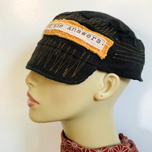 Load image into Gallery viewer, One of a kind design elements and embellishments upcycled from salvaged remnant fabric scraps, and hand sewn in Santa Cruz, CA. 100% cotton cap, handmade in Bali.   Yellow French terry and yellow stitching elements  Dark muted green colored cap Message: Journey towards the answers  100% cotton US size 7 1/8&quot; *  Wash cold, hang dry *see size chart for detailed measurement
