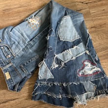 Load image into Gallery viewer, Denim jacket with patches and embroidery on a wooden surface

