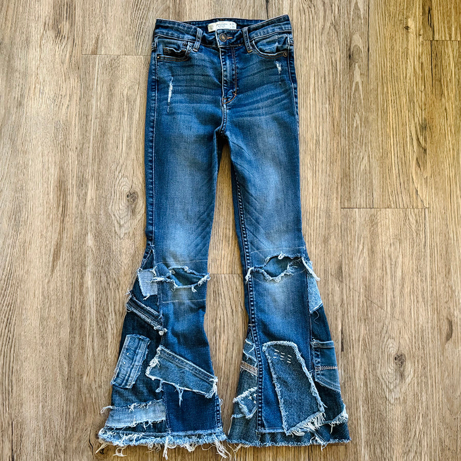 Upcycled from salvaged denim. Base jeans are from Abercrombie & Fitch Kids size 24 high rise (9/10), in great condition! Stretch denim with some intentional distress. Added denim bits and pieces, sashiko stitching for detail and embellishment, medium-flared bottoms. 

Handcrafted with love and intention.

One-of-a-kind
Fresh vibes
Size 24 kids (9/10)

Cold wash, like you would any pair of jeans, for longevity
Handmade in Santa Cruz, CA