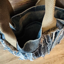 Load image into Gallery viewer, Upcycled from a whole lotta salvaged denim scraps, carefully sewn onto a salvaged denim bag with one interior pocket. This bag has both hand straps, as well as a shoulder strap for versatility! Not only are you choosing eco conscious with using textiles saved from the landfill, this bag is super unique and fly! DENIM DENIM DENIM!

Handcrafted with love and intention.

One-of-a-kind
Denim vibes

Handmade in Santa Cruz, CA
