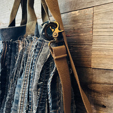 Load image into Gallery viewer, Upcycled from a whole lotta salvaged denim scraps, carefully sewn onto a salvaged denim bag with one interior pocket. This bag has both hand straps, as well as a shoulder strap for versatility! Not only are you choosing eco conscious with using textiles saved from the landfill, this bag is super unique and fly! DENIM DENIM DENIM!

Handcrafted with love and intention.

One-of-a-kind
Denim vibes

Handmade in Santa Cruz, CA
