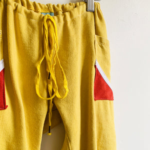 <p>Upcycled from yellow denim cotton adult skirt, and cotton hoodies. Cord tie waistband, adjustable and can be worn as long pants for small size, and as capris for bigger size. Side slits at bottoms on pant legs for flowy vibes, and two pockets for all the magical treasures.&nbsp; &nbsp;<br>Handcrafted with love and intention.</p> <ul> <li>Handmade in Santa Cruz, CA</li> <li>One-of-a-kind</li> <li>Soft denim cotton</li> <li>Size 3-5T</li> <li>Sunshine vibes</li> </ul>