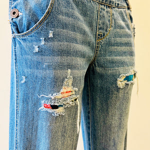 Upcycled from salvaged denim overalls, super colorful denim pants, and a lot of hand stitching and other denim scraps for embellishments and fun and unique detail. Base jeans are from&nbsp;American Rag Cie adult size 1 (XS/S adult), and in excellent condition! All intentional distress/rips that are significant have been also lined with fun fabric, so this piece is durable! Added amazing denim bits and pieces to create medium-flared bottoms.&nbsp;