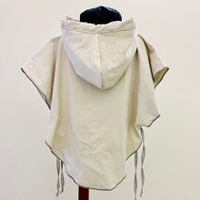 Load image into Gallery viewer, Upcycled from cotton lightweight canvas curtain and a salvaged Sure Design cotton t-shirt. Intentional revealed stitching, hand embroidered stitching for extra detail and whimsy, an oversized hood and side ties to give the option of more fitting or free flowing.

This poncho is lightweight, super cozy and total vibes for that walk along the beach, on your way to yoga class, or even out to dinner with your bestie! Easily rolls up so you can bring that extra layer of warm and fly with you anywhere!!!
