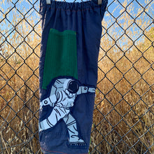Load image into Gallery viewer, Upcycled from high count cotton sheets, green cotton ribbed curtains, and a cotton graphic t-shirt. Wide leg, super comfortable and flow vibes, with revealed yellow and orange stitching for colorful vibes. Worn as capris length pants for taller ones, otherwise as long pants. Two deep pockets for all the treasures and magical things.  Handcrafted with love and intention.  Handmade in Santa Cruz, CA One-of-a-kind Size 6-8T - capris shorts, slender fit
