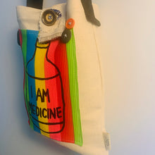 Load image into Gallery viewer, Upcycled from a cotton canvas duck adult sleeve and an &quot;I AM MEDICINE&quot; hand printed graphic patch by Shari Elf, and salvaged belt (as strap) buttons. We are all our own medicine if you tune in.   One-of-a-kind Shoulder tote bag Over-the-shoulder bag Handmade in Santa Cruz, CA I AM MEDICINE vibes
