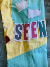 Load image into Gallery viewer, Upcycled from salvaged tee shirts and salvaged graphic word tees. All about comfort, all about being HONOR, and definitely all about being SEEN.   Handcrafted with love and intention.   Handmade in Santa Cruz, CA One-of-a-kind Conscious vibes Pocket for magical finds  Size 7-8 youth 
