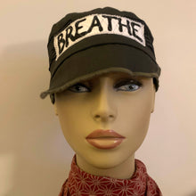 Load image into Gallery viewer, One of a kind design elements and embellishments upcycled from salvaged remnant fabric scraps, and hand sewn in Santa Cruz, CA. 100% cotton cap, handmade in Bali.   It&#39;s medicine: BREATHE  Army green colored cap High vibration  100% cotton US size 7 3/8&quot; *  Wash cold, hang dry *see size chart for detailed measurement
