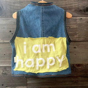 Upcycled from jeans, graphic tee, and salvaged embellishments. Lined with cotton tee. This cute vest is the perfect layer of warmth and love.   Handcrafted with love and intention.   Upcycled and one-of-a-kind Handmade in Santa Cruz, CA Size 2-3T I AM HAPPY 