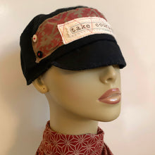 Load image into Gallery viewer, One of a kind design elements and embellishments upcycled from salvaged remnant fabric scraps, and hand sewn in Santa Cruz, CA. 100% cotton cap, handmade in Bali.   Conscious message: Take courage  Native print graphic Black colored cap Button embellishments 100% cotton US size 7 1/8&quot; *  Wash cold, hang dry *see size chart for detailed measurement
